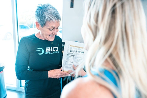 Terri Eaton reviewing functional training class schedule at Bild by Coach O gym