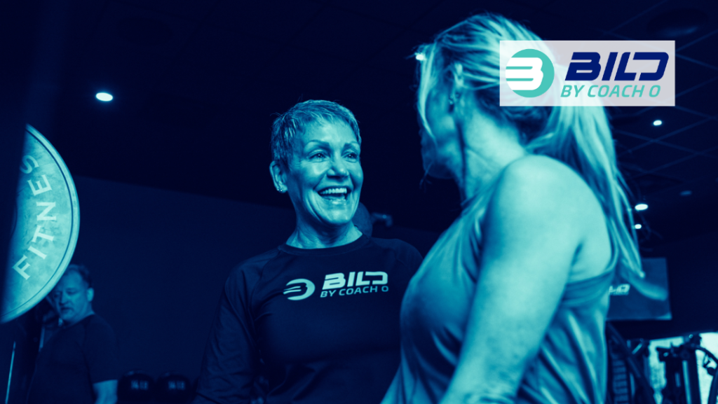 Trainer at the best gym Naples FL working with a Bild member on her form