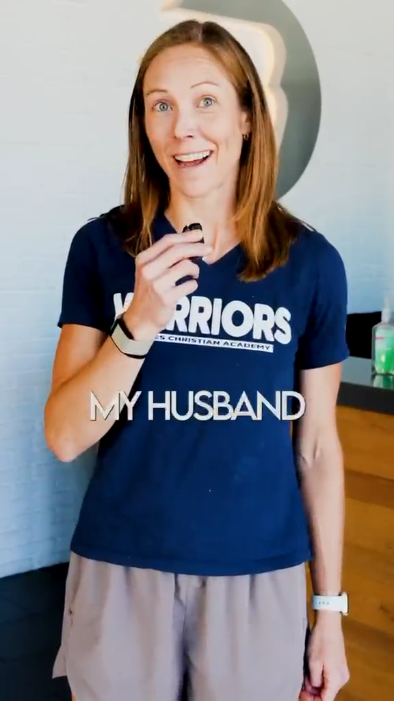 Close-up of a woman wearing a blue Warriors fitness t-shirt.