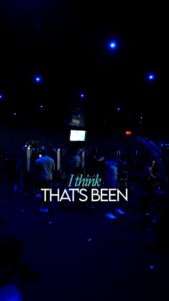 Person working out in a modern dark-lit gym with blue neon lights in Bild by gym in naples